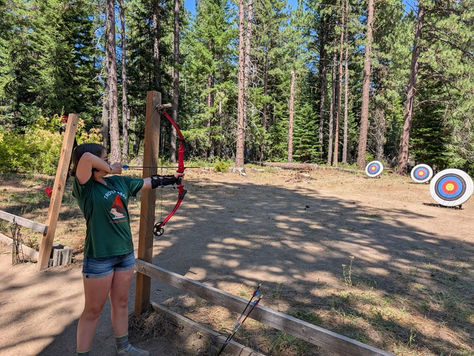 A Scout pulls her bowstring before putting another arrow into her target.