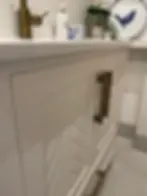 White patterned bathroom cabinet with gold handles