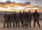 a group of 10 Marines on a sandy mountain at sunrise