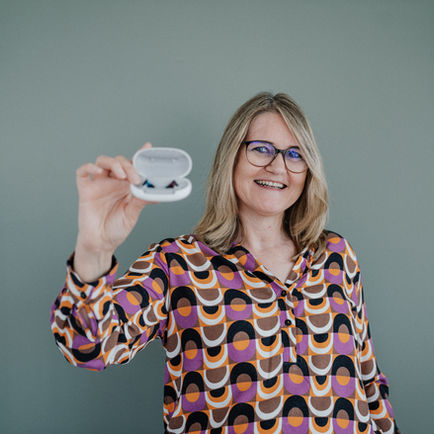 Hörakustikerin präsentiert Hörgerät