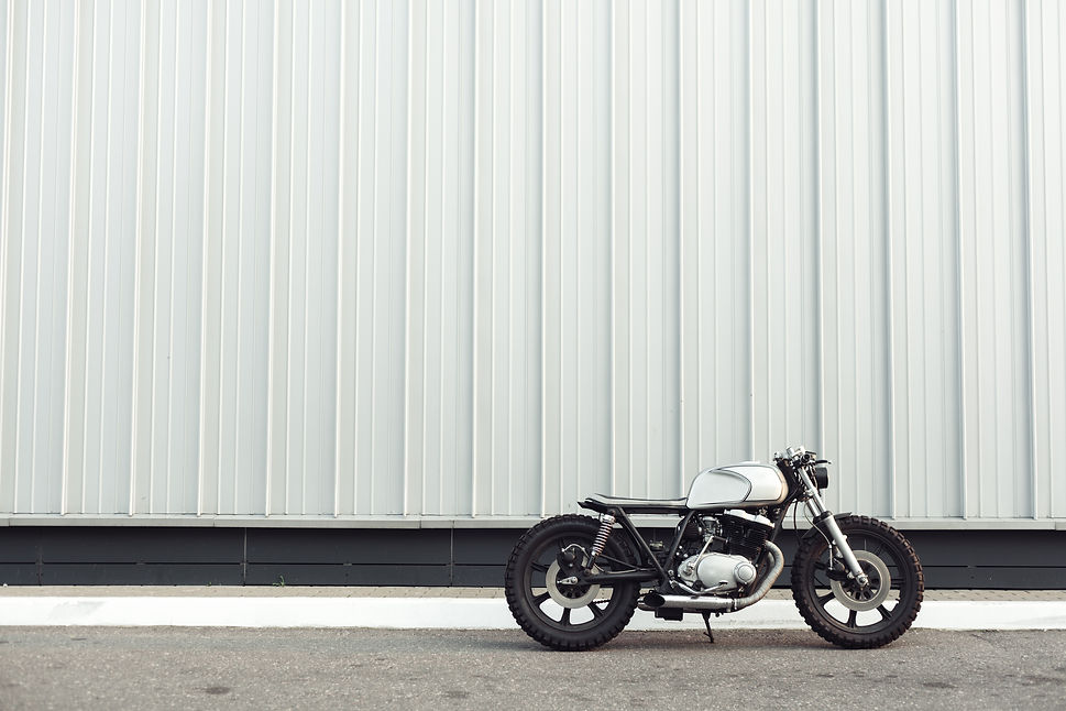 motorcycle-standing-in-dark-building-in-rays-of-su-2021-08-26-16-35-38-utc.jpg
