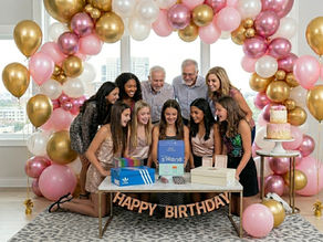 A group of teen girls watch their friend open up her gift