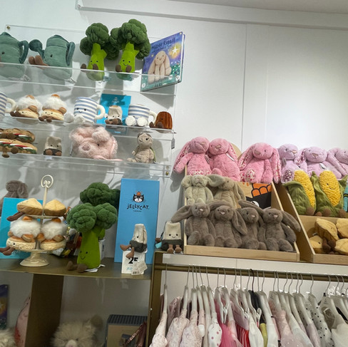 A wide selection of Jellycat plushies displayed on shelves inside the Designer's Cat store in Glyfada, Athens, Greece.