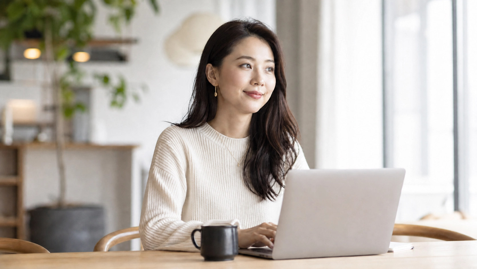 自宅サロンやカフェでPCを開いてスマートに働く女性