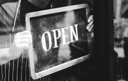 man-putting-on-shop-open-sign-2021-08-27-00-02-37-utc