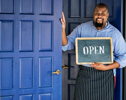 a-cheerful-small-business-owner-with-open-sign-2021-08-27-00-05-57-utc