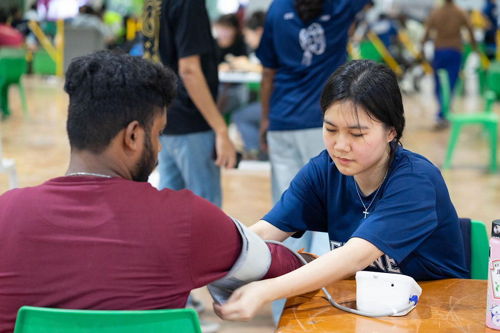 Student volunteer assisting in taking the blood pressure using an automatic sphygmomanometer