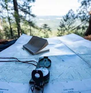 Land navigation tools rest on a map during Survival, Evasion, Resistance and Escape training in Northern California, Jan. 29, 2026.
