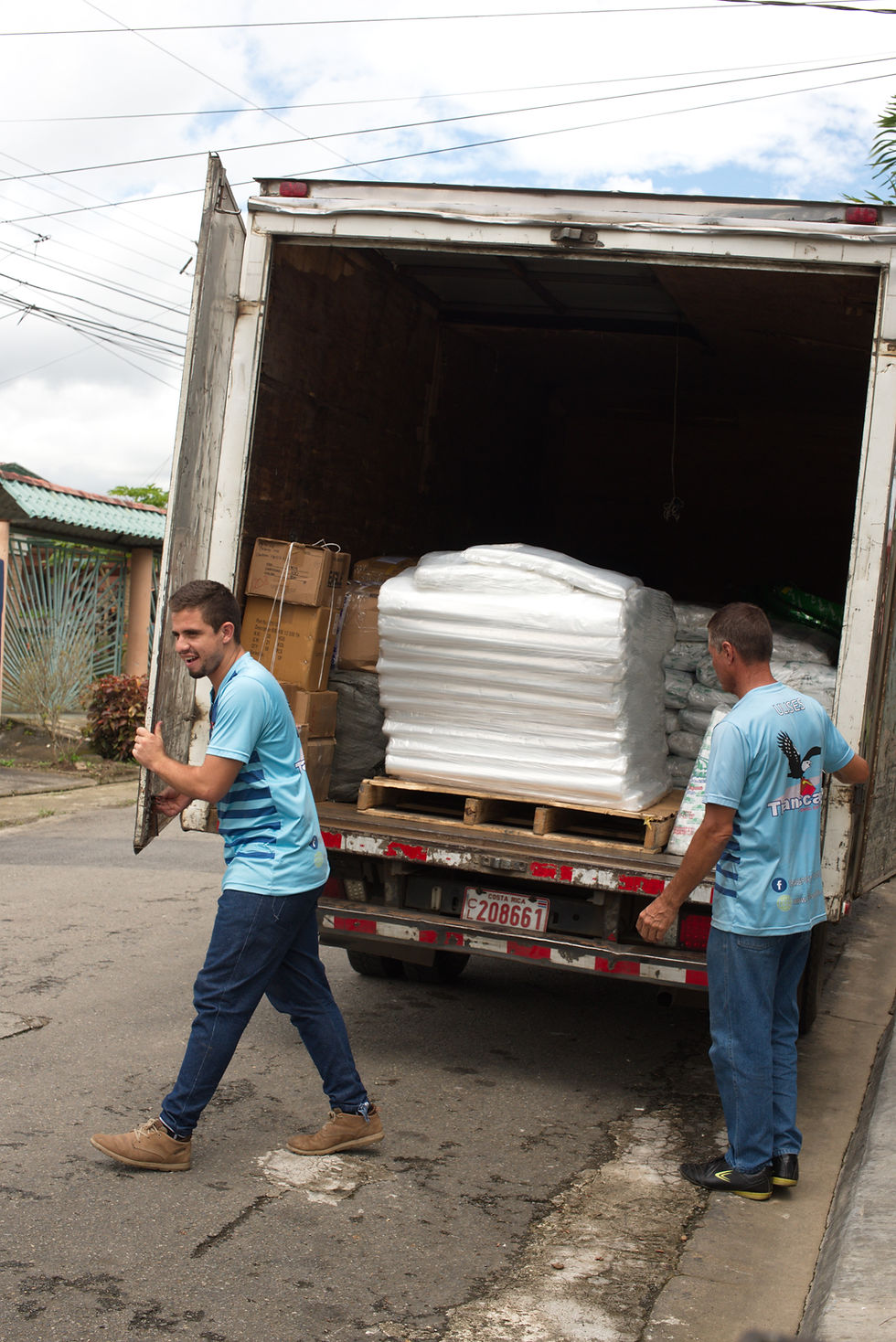 Personal de una empresa de transporte en Costa Rica cargando camión.