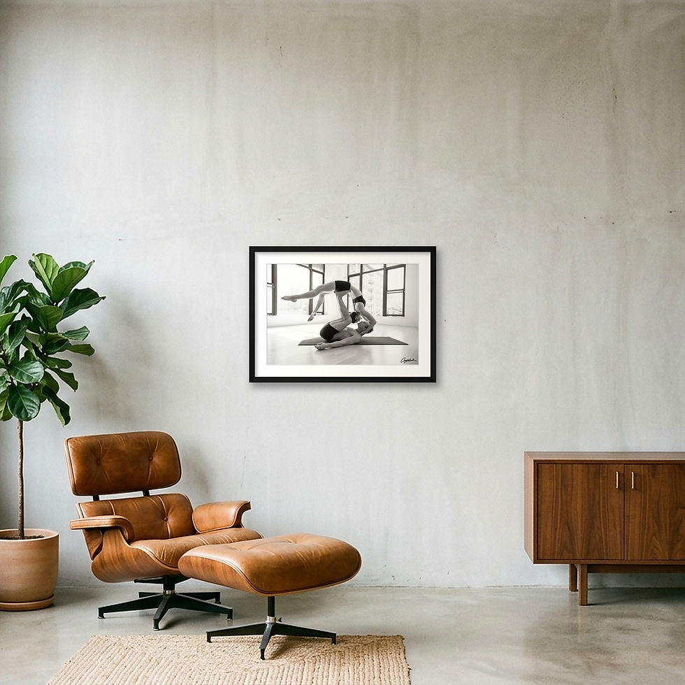 Thumbnail: Black and white acro yoga portrait of two athletes performing a partner balance pose indoors with large windows and city