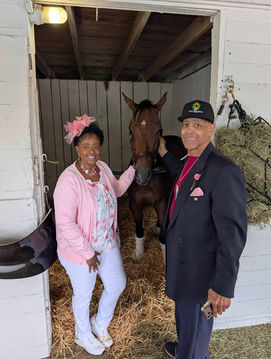 Father and daughter posing with a horse.