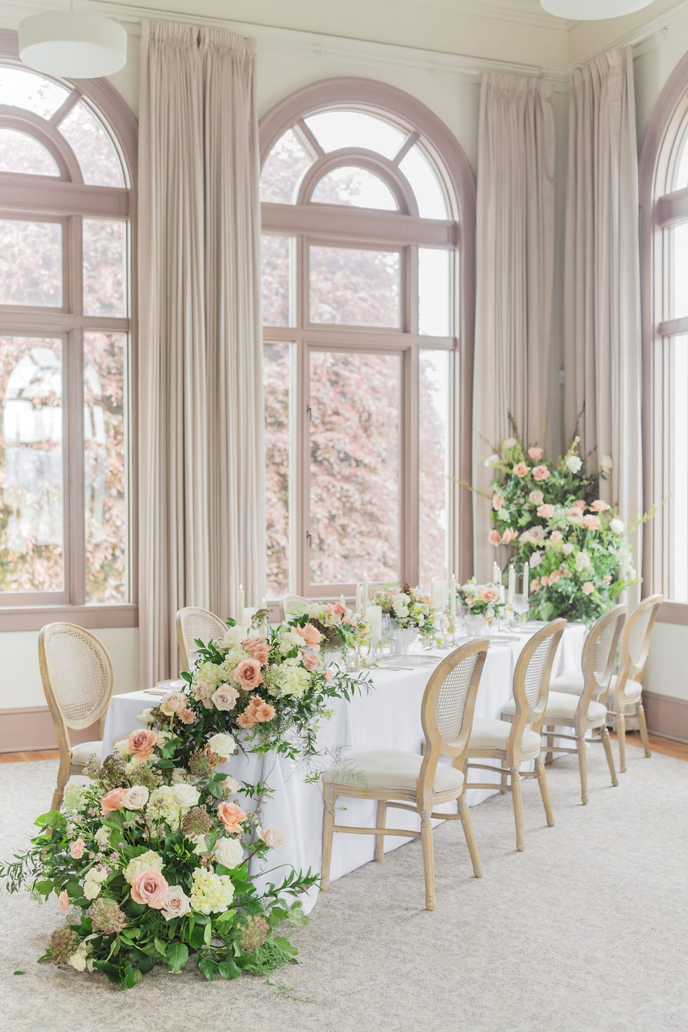 Elegant wedding table with floral runners and arched windows
