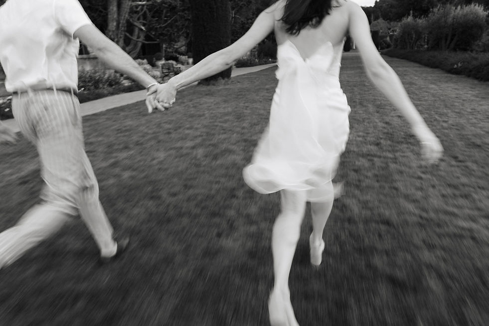 Couple holding hands and running through a field