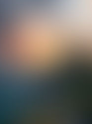 A fairytale Castle sits high on a hill overlooking the sea at sunset.