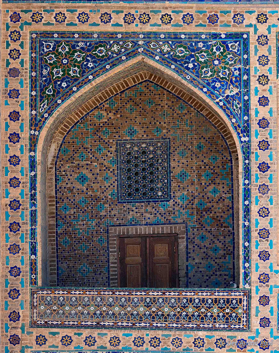 A recessed niche covered with floral ceramic work and patterned tile inlay (Ulugh Beg Madrasa)