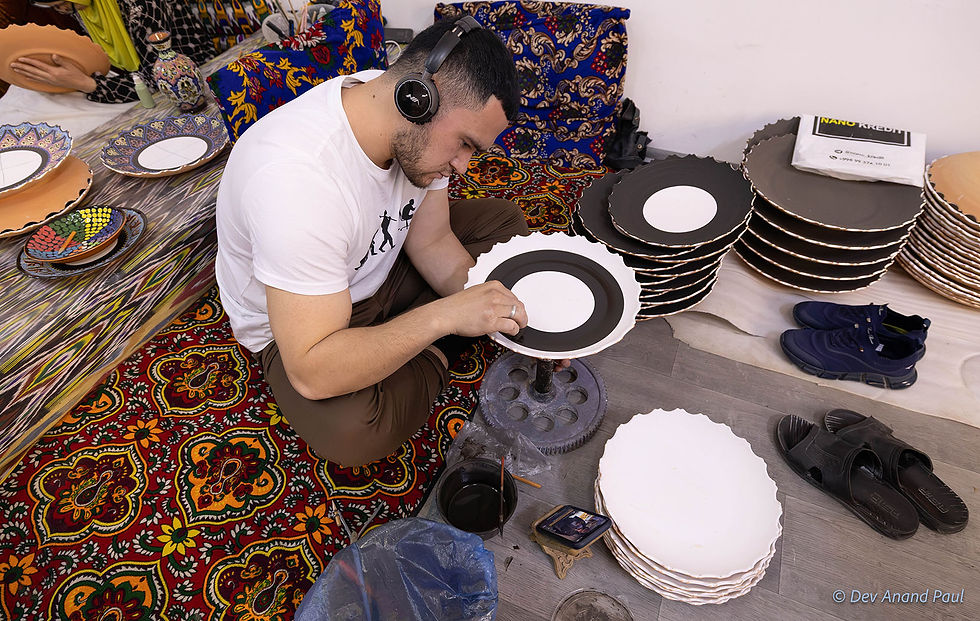 An artisan, at the Mingboshi Ceramics workshop, painting intricate motifs on the angob-coated surface of a ceramic plate
