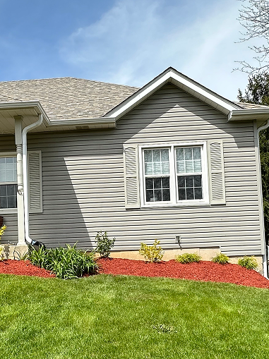 Red mulch with small shrubs planted and freshly cut grass.