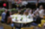 Stylish group dining at Pera Soho during New York Fashion Week, where guests enjoy Mediterranean dishes in a chic garden setting.