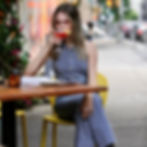Fashion-forward scene at Pera Soho: a woman in a blue-and-white striped outfit sits elegantly with a mezze platter, silk scarf, and gold purse, embodying NYFW garden style.