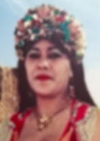 Women's face, she wears gold chocker and earrings and a very large headband decorated with beads and sequins.