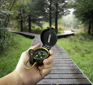 man holding compass with two paths ahead.jpg