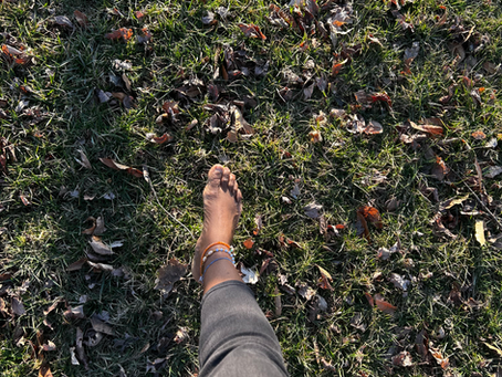 a persons foot on the ground, grounding in the sun.