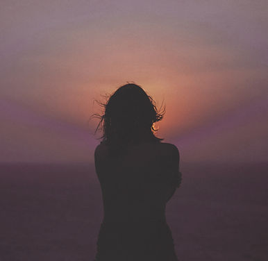 Pensive woman looking at a sunset
