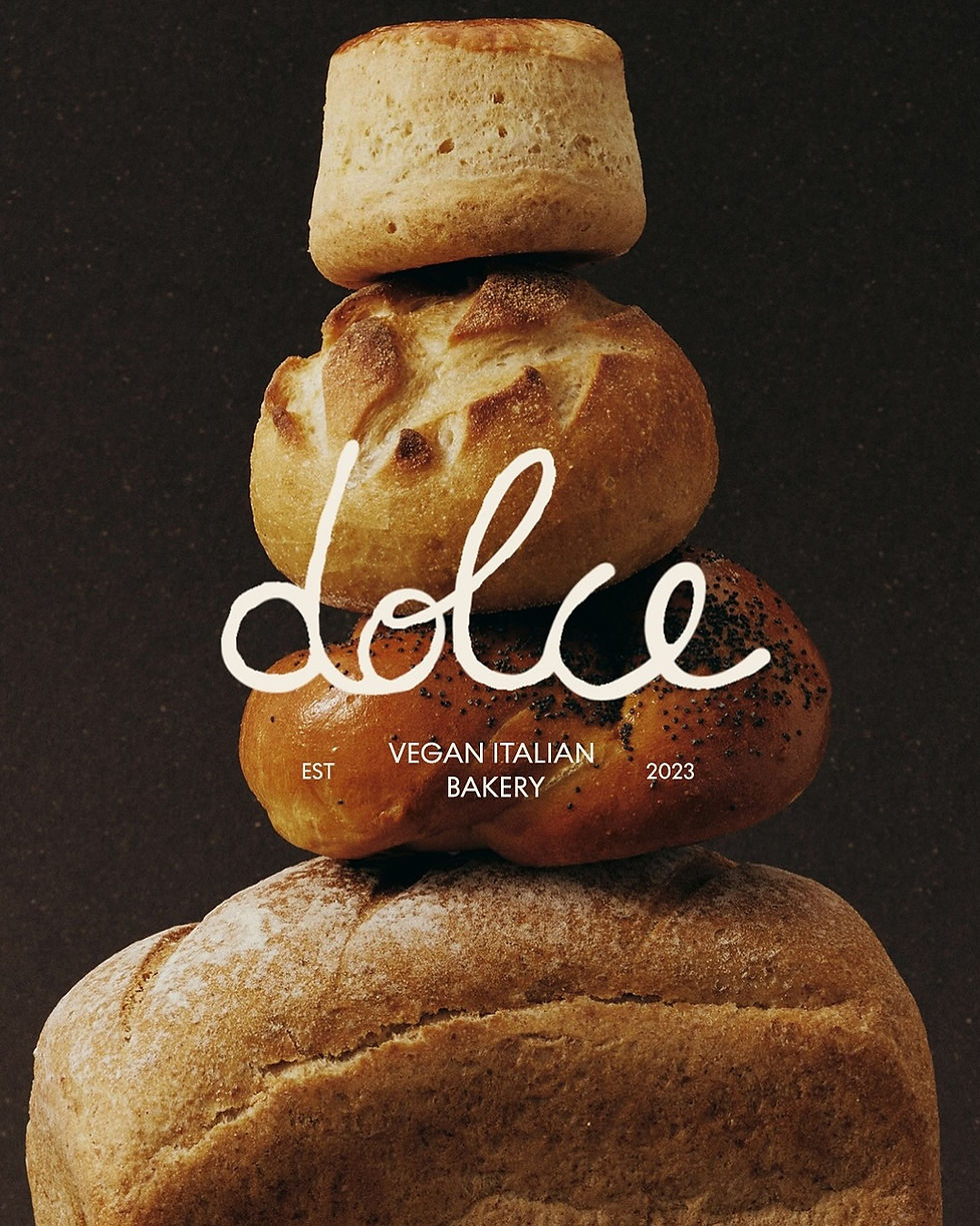Dolce vegan Italian bakery brand identity by glint.thestudio, stacked bread tower with handwritten script logo on dark background