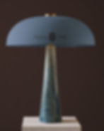 table lamp mockup, domed shade on blue ceramic base, brass fittings, stone plinth, espresso and terracotta walls, hotel brand
