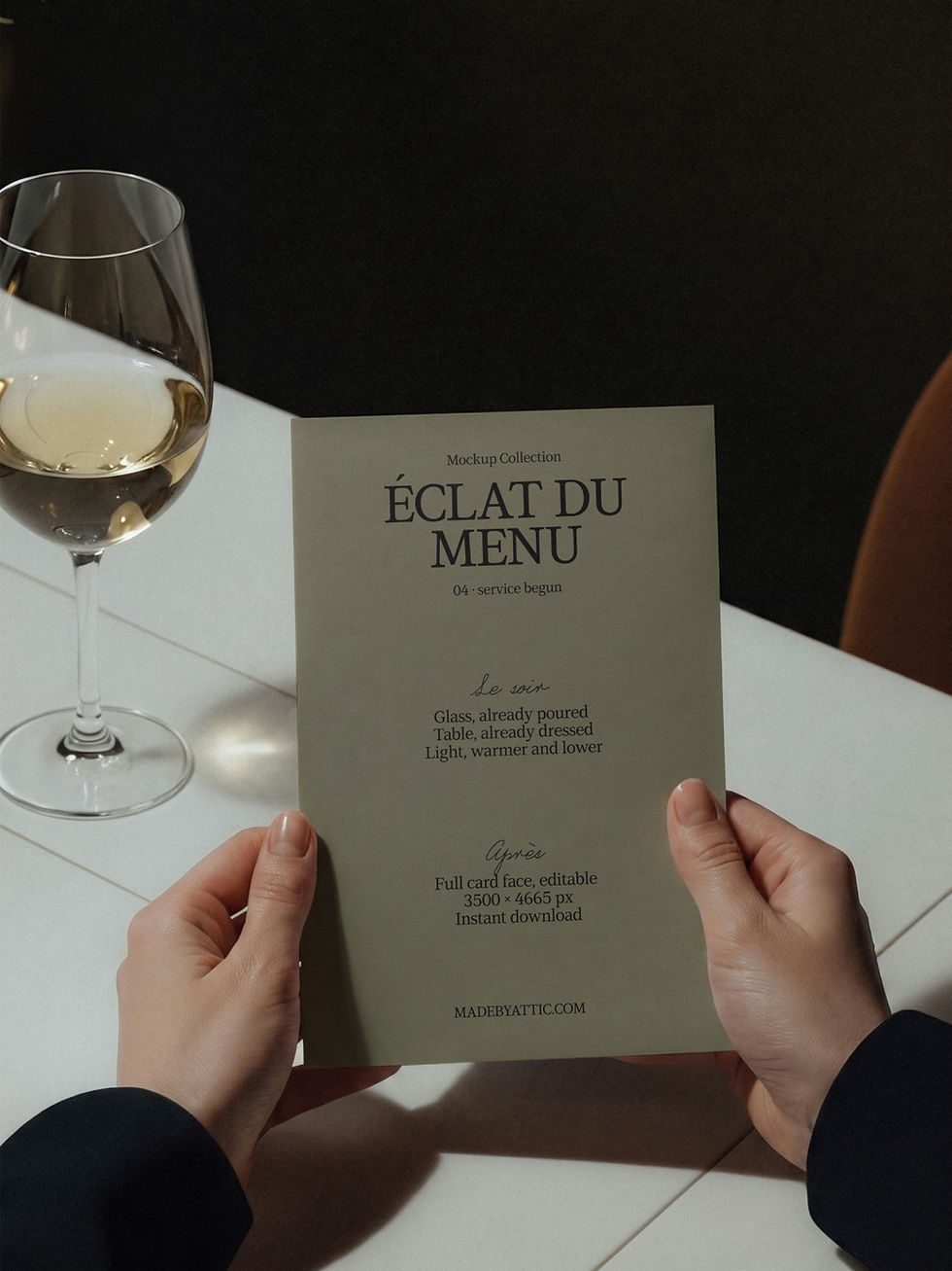 Menu mockup held above a tiled restaurant table beside a poured glass of white wine