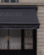 storefront mockup, parisian awning, charcoal canvas, scalloped trim, shop window, Haussmann building, luxury retail mockup, m