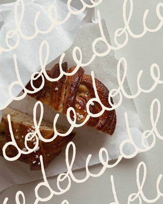 Close crop of Dolce handwritten script logotype, vegan Italian bakery branding concept by glint.thestudio