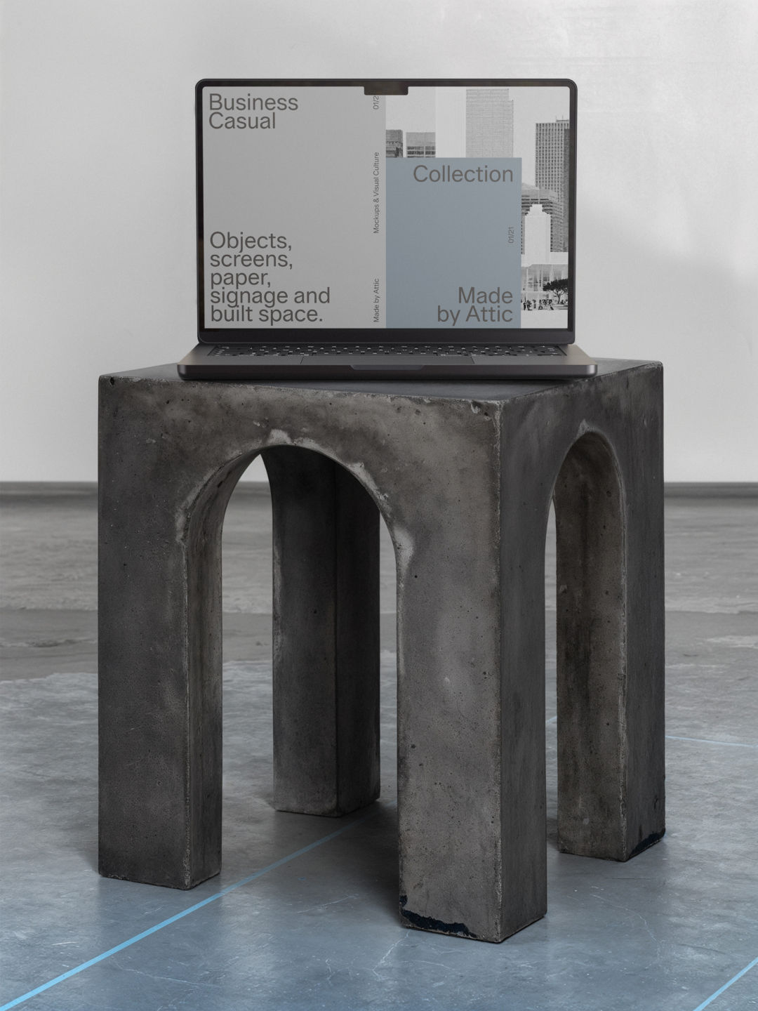 MacBook Pro mockup displayed on a sculptural concrete plinth in a grey architectural interior