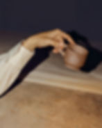 Hand holding a white espresso cup with a sharp shadow cast on a blue and white background.