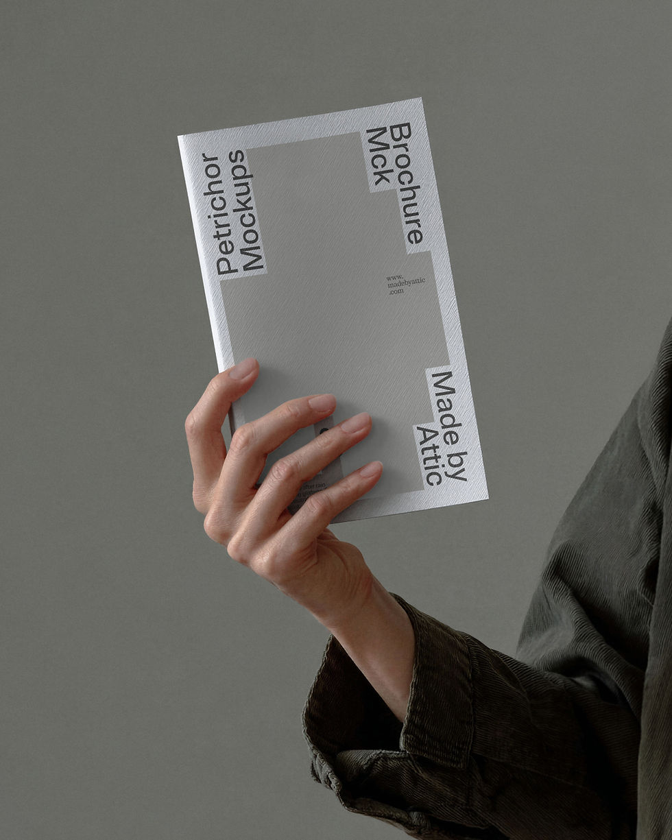 booklet mockup, white textured booklet, hand holding, corduroy jacket, grey background, editorial print mockup, made by attic