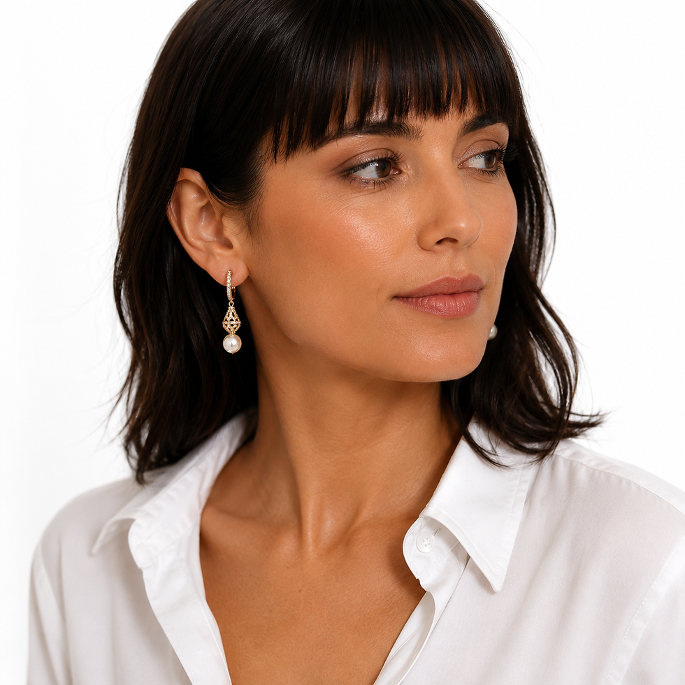 Woman wearing elegant gold plated pearl drop earrings with white blouse