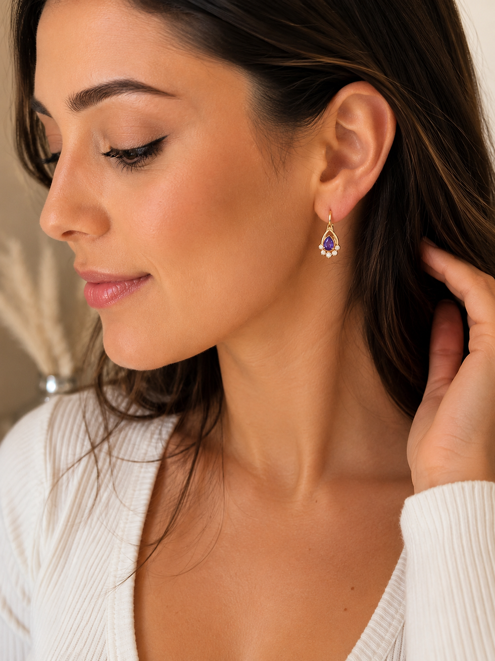 Thumbnail: Woman wearing Xuping 18K gold colour plated drop earrings with a violet teardrop crystal.