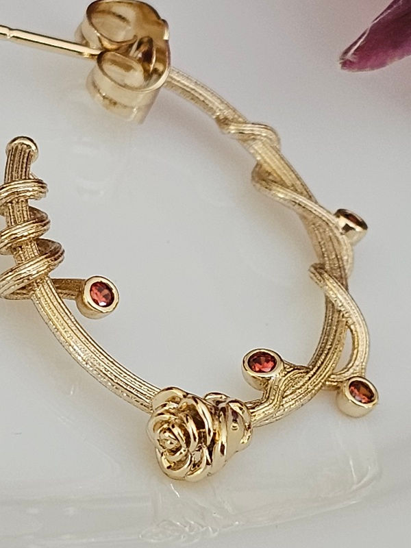 Thumbnail: Close-up of red cubic zirconia and rose detail on floral hoop earring