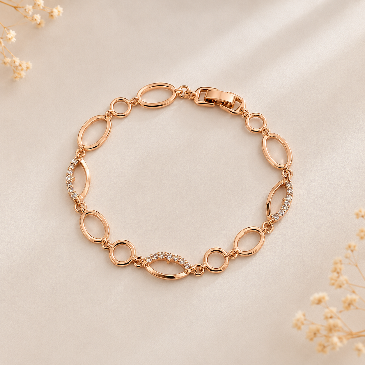 Rose gold plated link bracelet with cubic zirconia crystals, featuring oval and marquise shaped elements, displayed on a soft