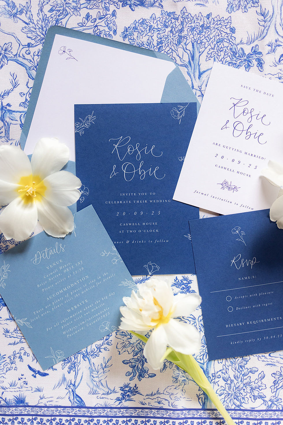 A beautiful wedding stationery suite in blue and white tones with floral illustrations, hand drawn calligraphy and classic typography.