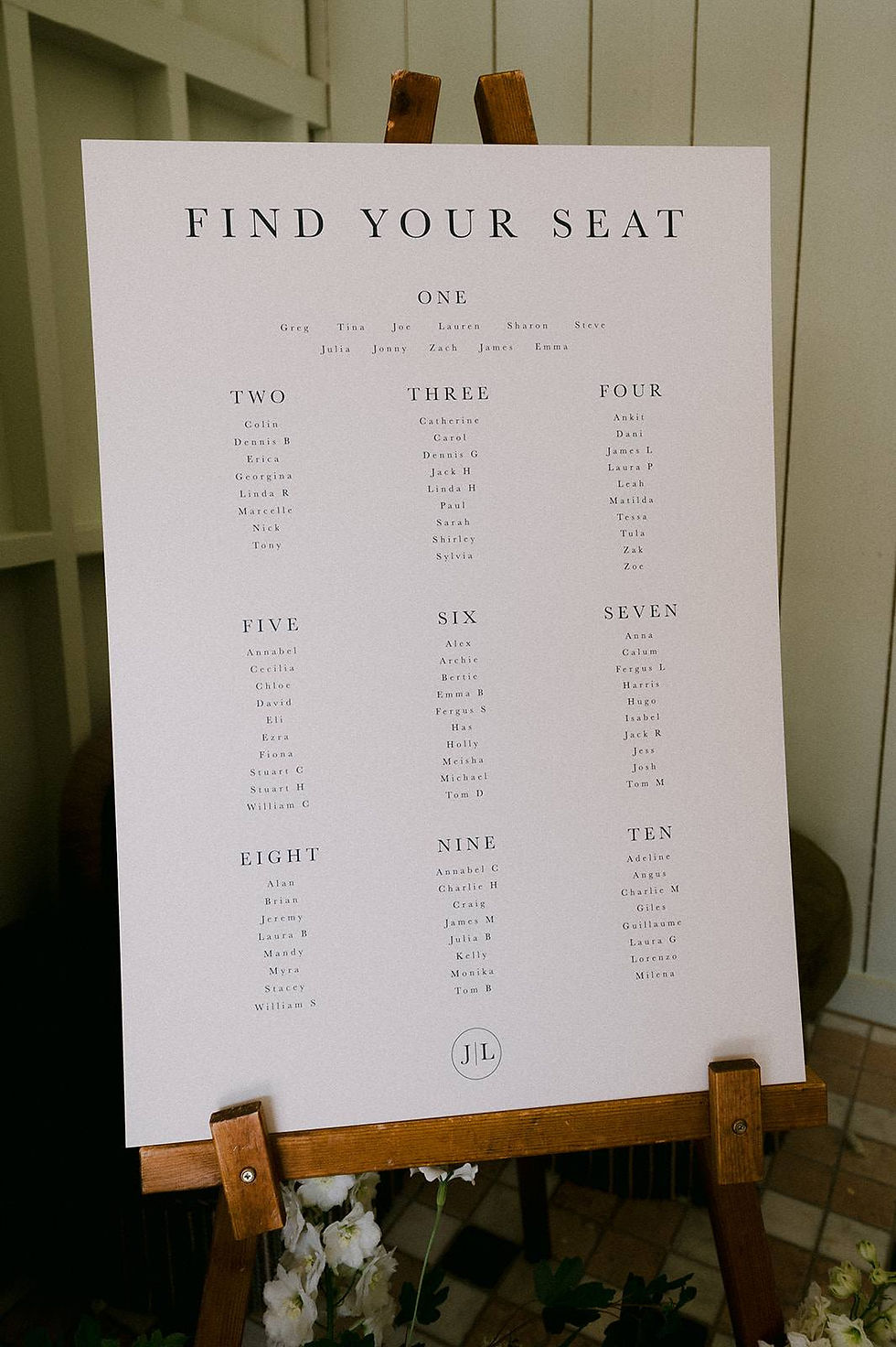 A monochrome wedding table plan placed on an easel