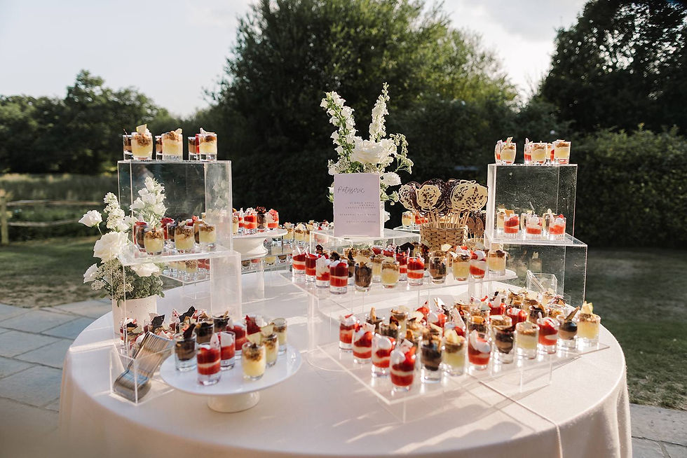 A small wedding sign with a calligraphy header, styled amongst an impressive dessert table