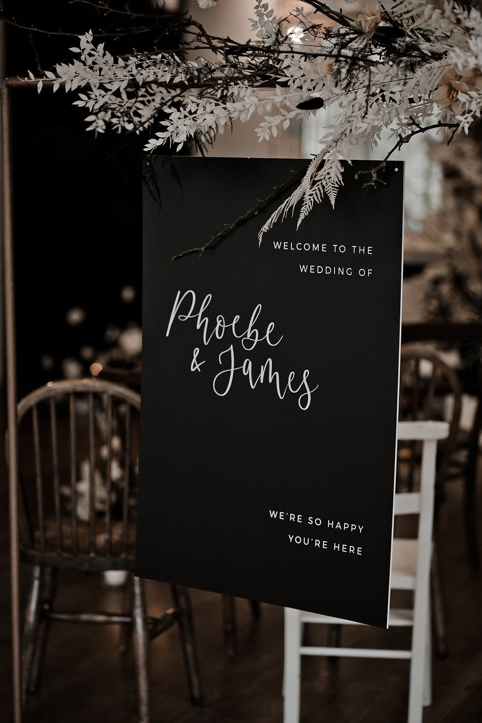 Wedding welcome sign designed with white calligraphy and text on a black background.