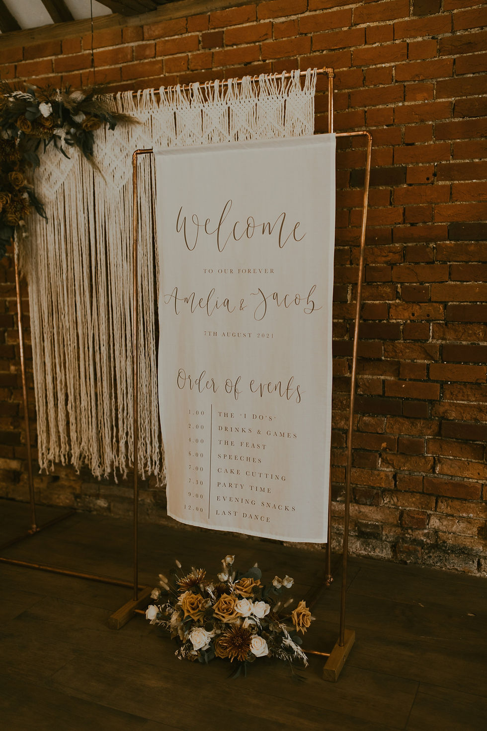 Modern calligraphy welcome and order of events sign on a white fabric, hung onto a wire frame