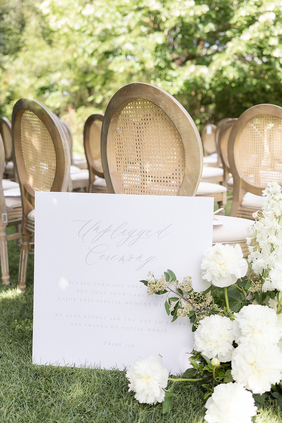 A large sign requesting an unplugged ceremony designed with calligraphy on white card.
