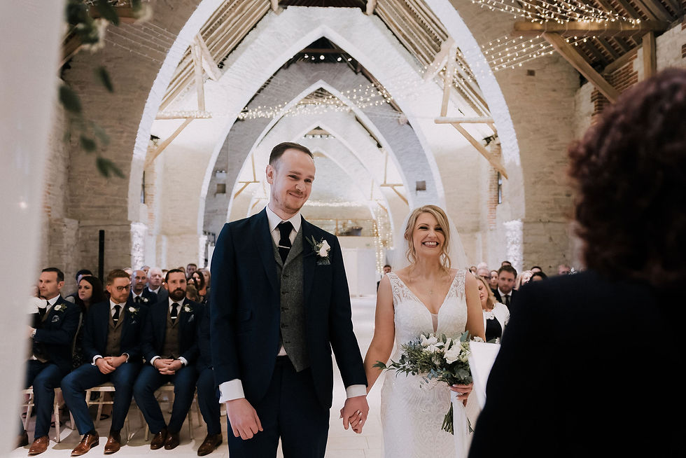 The bride and groom hold hands during their wedding ceremony.