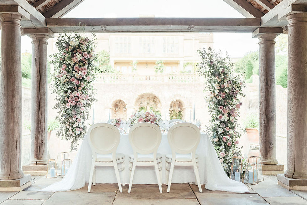 A romantic wedding table set up based on a pastel colour palette with lace, gold and white cutlery and pale blue crockery