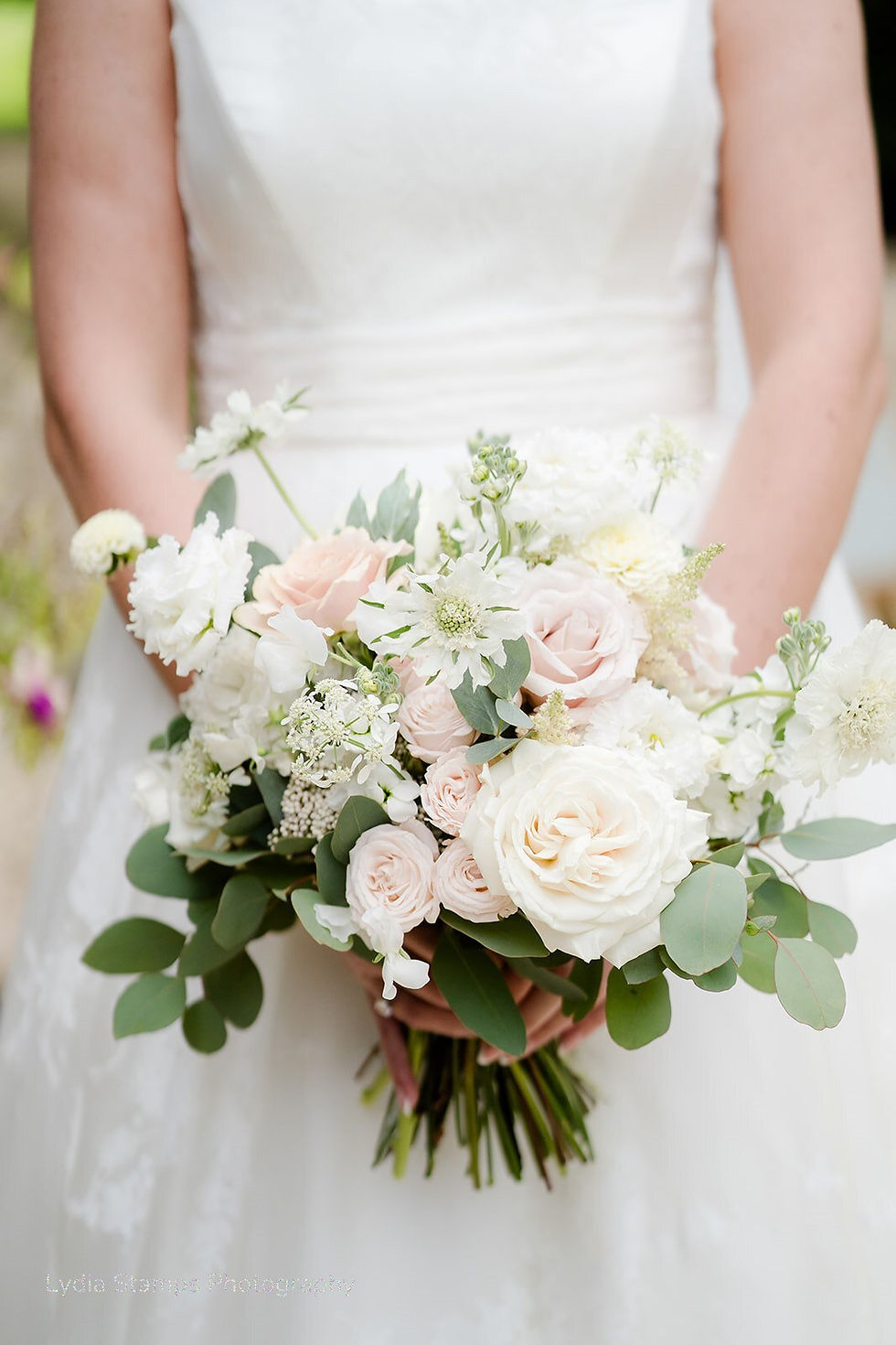 A close up of the bridal bouquet with pretty white and pale pink flowers