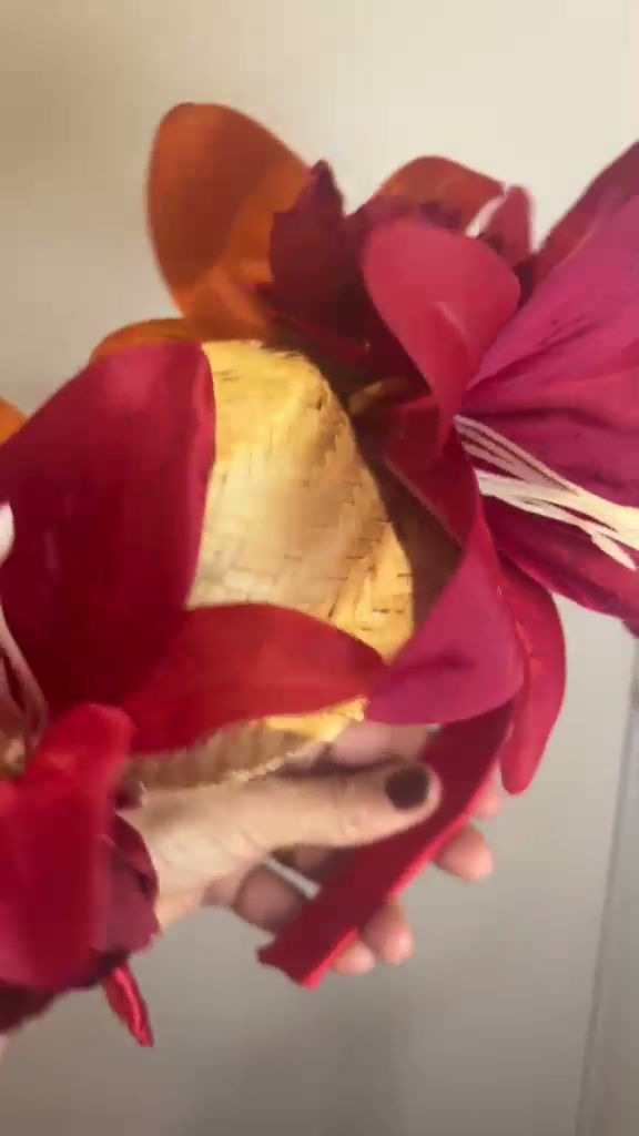 Miniatura: Tiara artesanal com base de palha trançada, decorada com grandes lírios vermelhos e acabamento em cetim, sobre fundo de linho