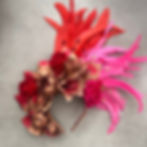 "Tiara de Carnaval volumosa com flores pintadas em pink neon e rosê, decorada com folhas metálicas e penas altas